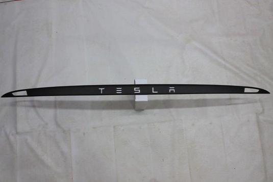 Carbon rear trunk trim with LEDs for Tesla Model S from Tuning Shop, made of genuine carbon fiber with a grey gloss UV-resistant coating.