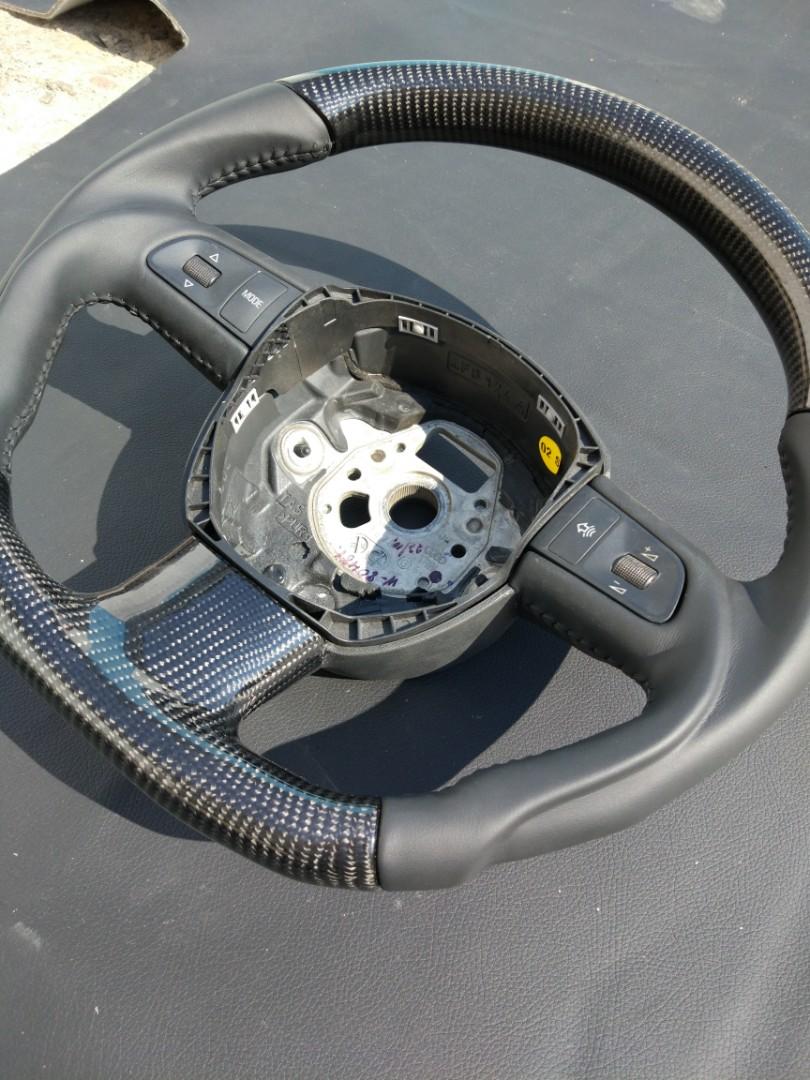 OEM remanufactured Audi A3 A4 A6 Q7 steering wheel with carbon fiber and black leather from Tuning Shop, featuring a flat bottom and changed anatomy.