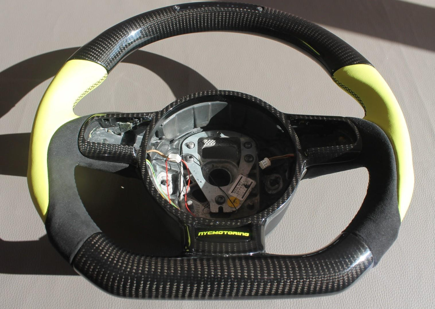 OEM remanufactured Audi R8 steering wheel with carbon fiber, yellow leather, alcantara, flat bottom, and LED panel from Tuning Shop.