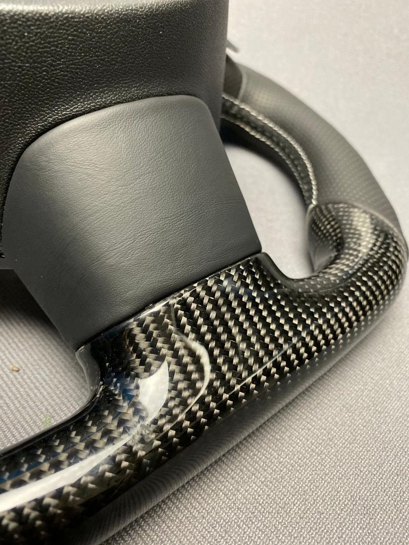 OEM remanufactured Audi S8 steering wheel with carbon fiber, perforated black leather, flat bottom, and piano black center from Tuning Shop.