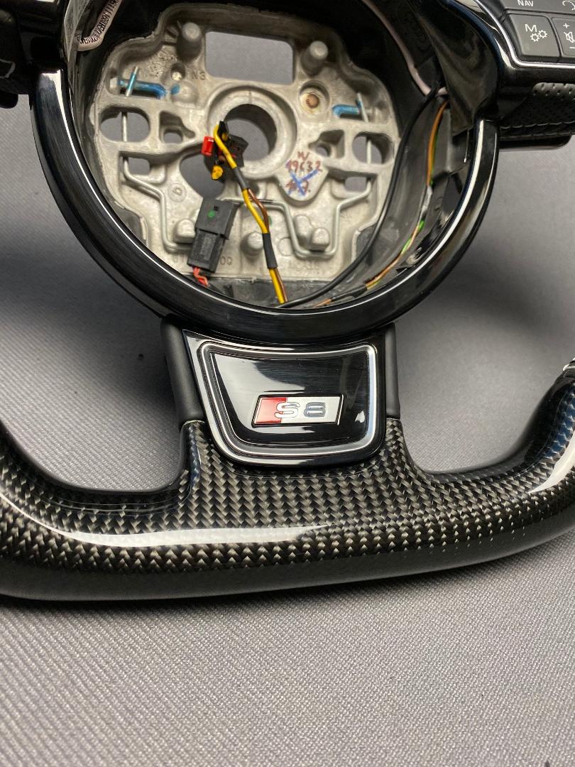 OEM remanufactured Audi S8 steering wheel with carbon fiber, perforated black leather, flat bottom, and piano black center from Tuning Shop.