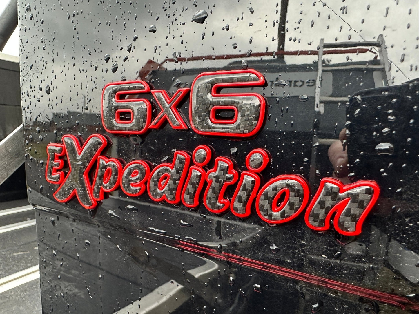 6x6 Expedition Emblem Logo 2-Component Red Metal with Carbon for Mercedes W463 6x6 from Tuning Shop, high-quality metal and carbon construction.